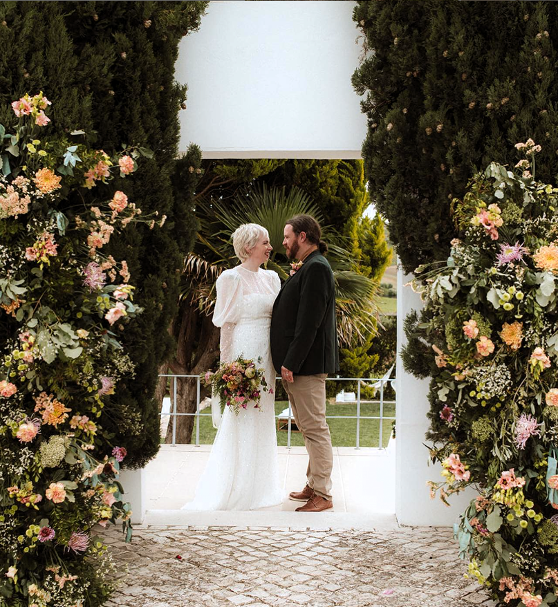 Captura de ecrã 2023-09-08 200246 Mulher com ramo de flores na mão a olhar para homem, em um casamento